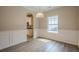 Dining room with hardwood floors, wainscoting and views to the kitchen through an arched doorway at 433 Orchid Ln, Canton, GA 30114