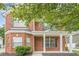 Two-story brick home featuring a covered front porch with white columns and lush landscaping at 433 Orchid Ln, Canton, GA 30114