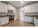 Bright kitchen features white cabinets, stainless steel appliances, and granite countertops at 433 Orchid Ln, Canton, GA 30114