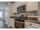 Bright kitchen features white cabinets, stainless steel appliances, and granite countertops at 433 Orchid Ln, Canton, GA 30114