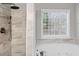 Bright bathroom featuring a tiled walk-in shower, spa tub, and window with exterior view at 1029 Chaterly Ct, Riverdale, GA 30296
