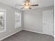 Bedroom features neutral paint, carpet, two windows, and a ceiling fan at 1029 Chaterly Ct, Riverdale, GA 30296