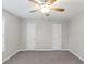 Bedroom features neutral paint, carpet, a ceiling fan, and two doors for easy access at 1029 Chaterly Ct, Riverdale, GA 30296