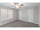 Bedroom features neutral paint, carpet, a ceiling fan, and two doors for easy access at 1029 Chaterly Ct, Riverdale, GA 30296