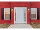 Close up of a white front door with sidelights and stylish sconces on a red brick facade at 1029 Chaterly Ct, Riverdale, GA 30296