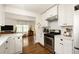 Well-lit kitchen with stainless steel appliances, white cabinets, and hardwood floors leading to the living room at 1608 Terry Mill Se Rd, Atlanta, GA 30316