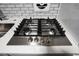 Close-up on the new gas cooktop with four burners and clean, white countertops at 2965 Pharr Court South Nw # 110, Atlanta, GA 30305