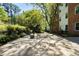 Charming outdoor patio with seating surrounded by mature trees and lush landscaping, perfect for relaxation at 2965 Pharr Court South Nw # 110, Atlanta, GA 30305