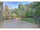 Back deck with wood railing offers views of the private, tree-lined backyard at 304 N Briar Rdg, Woodstock, GA 30189