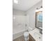 Bathroom with white tile, shower-tub combo, wood vanity and modern fixtures at 304 N Briar Rdg, Woodstock, GA 30189