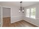 Bright dining room featuring wood-look flooring, natural light, and modern chandelier at 304 N Briar Rdg, Woodstock, GA 30189
