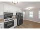 Cozy eat-in kitchen featuring white cabinets, stainless appliances, wood floors, and natural light at 304 N Briar Rdg, Woodstock, GA 30189