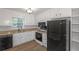 Well-lit kitchen with white cabinets, granite countertops, stainless steel appliances, and wood-look flooring at 304 N Briar Rdg, Woodstock, GA 30189