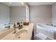 Bathroom with a double sink vanity, a soaking tub and neutral colored tile at 873 Edgewater Cir, Marietta, GA 30062
