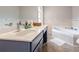 Bathroom with a double sink vanity, a soaking tub and neutral colored tile at 873 Edgewater Cir, Marietta, GA 30062