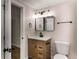 Bathroom featuring hardwood floors, a modern sink and vanity, and a decorative mirror at 2358 Larchwood Sw Rd, Atlanta, GA 30310