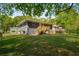 Large green backyard featuring the back of the home with gray painted brick at 2358 Larchwood Sw Rd, Atlanta, GA 30310