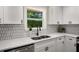 Charming kitchen features white cabinets, quartz countertops, stainless steel appliances, and a stylish backsplash at 2358 Larchwood Sw Rd, Atlanta, GA 30310