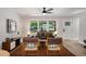 Inviting living room with a ceiling fan, large windows, and modern decor, open to the kitchen at 2358 Larchwood Sw Rd, Atlanta, GA 30310