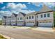 Charming new townhome exteriors featuring brick accents, garages, and beautiful landscaping at 2405 Malster Ln, Lawrenceville, GA 30043