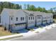 View of new townhome construction, featuring white siding and two-car garages at 2405 Malster Ln, Lawrenceville, GA 30043