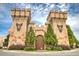 Exterior view of Medieval Times castle entrance with stone towers, heraldic emblems, and lush landscaping at 2405 Malster Ln, Lawrenceville, GA 30043