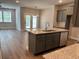 Modern kitchen featuring a central island with granite countertops and stainless steel appliances at 2405 Malster Ln, Lawrenceville, GA 30043