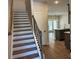 Inviting staircase with hardwood steps and black iron railing leading to an open-concept kitchen at 2405 Malster Ln, Lawrenceville, GA 30043