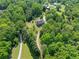 Beautiful aerial view of home nestled amongst mature trees on a private lot with a long drive at 675 Jack Page Ln, Canton, GA 30115