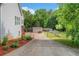 View of the backyard including a storage shed, a driveway and mature landscaping at 675 Jack Page Ln, Canton, GA 30115