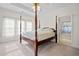 Bedroom with a four-poster bed, tray ceiling, and ensuite bathroom with a view at 675 Jack Page Ln, Canton, GA 30115