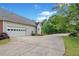 Spacious driveway leading to a two-car garage surrounded by mature trees and landscaping at 675 Jack Page Ln, Canton, GA 30115