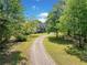 Scenic front yard view of home framed by trees and a long gravel driveway at 675 Jack Page Ln, Canton, GA 30115
