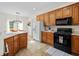 Kitchen with oak cabinets, black appliances, tile floor and view into the dining room at 675 Jack Page Ln, Canton, GA 30115