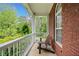 Cozy porch with wooden bench, red brick and white railings at 675 Jack Page Ln, Canton, GA 30115