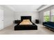 Spacious bedroom featuring a plush black tufted bed frame and a large window for natural light at 1025 Cherryfield Run, Marietta, GA 30008