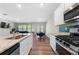 Modern kitchen flows into living area, featuring granite counters and stainless steel appliances at 1025 Cherryfield Run, Marietta, GA 30008