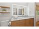 Bathroom with a floating wood shelf and a bright LED mirror over a granite countertop at 1255 Cold Harbor Dr, Roswell, GA 30075