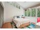 Light-filled bedroom with hardwood floors, queen bed, and green views from large windows creating a serene atmosphere at 1255 Cold Harbor Dr, Roswell, GA 30075