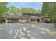 Beautifully landscaped home boasts a contemporary design, an expansive driveway, and mature trees at 1255 Cold Harbor Dr, Roswell, GA 30075