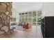 Bright living room with floor to ceiling windows, stone fireplace, and hardwood floors at 1255 Cold Harbor Dr, Roswell, GA 30075