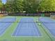 This listing features well maintained tennis courts with green and blue coloring and mature tree backdrop at 1255 Cold Harbor Dr, Roswell, GA 30075
