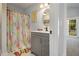 Well-lit bathroom with gray vanity, decorative shower curtain, and a view of the outdoor balcony at 14020 Tributary Ln, Villa Rica, GA 30180