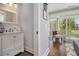 Bright half bathroom with a white vanity and stylish mirror, conveniently located near the living area at 14020 Tributary Ln, Villa Rica, GA 30180