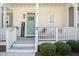 Inviting front porch with rocking chairs, a welcome sign, and a vibrant turquoise door, enhancing curb appeal at 14020 Tributary Ln, Villa Rica, GA 30180