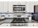 Close up of the stainless stove and microwave showing the tile backsplash and granite counters at 1429 Ferocity Ridge Nw Way # 12, Kennesaw, GA 30152
