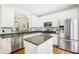 Bright kitchen offers stainless appliances, a center island, granite countertops, and white cabinetry at 1429 Ferocity Ridge Nw Way # 12, Kennesaw, GA 30152