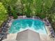 Community pool with chaise lounges and umbrella tables surrounded by trees at 1429 Ferocity Ridge Nw Way # 12, Kennesaw, GA 30152