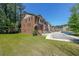 Brick townhome featuring a two-car garage, front stairs, and grassy front yard at 3155 Boldmere Se Trl # 3, Smyrna, GA 30080
