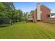 Spacious backyard with green grass, trampoline, playset, and a wooden deck at 100 Coldwater Creek Dr, Mcdonough, GA 30252